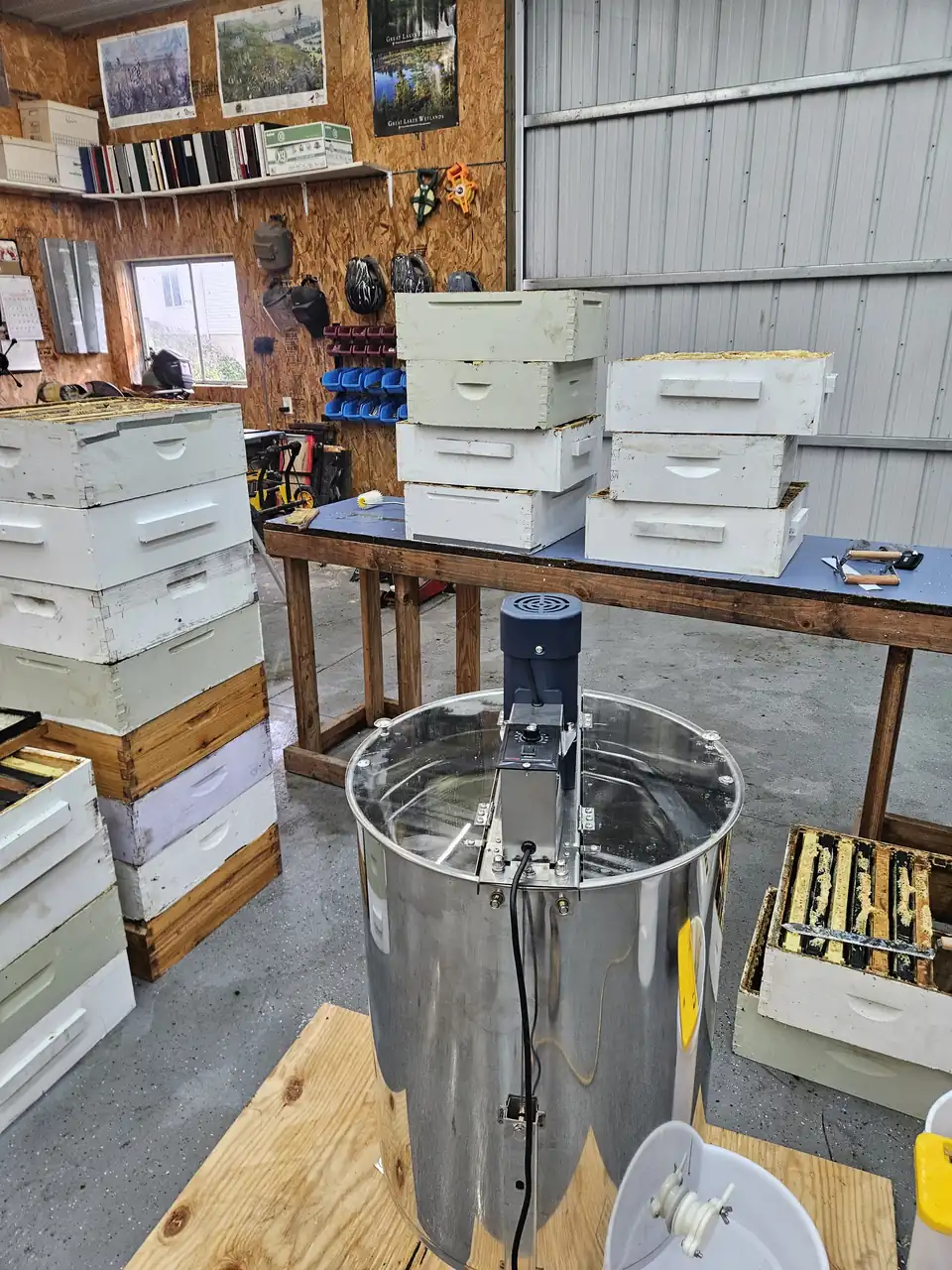 Stainless steel honey extractor and hive boxes in the barn